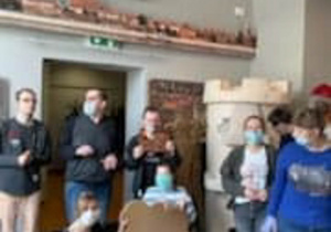 Zdjęcie grupowe uczestników Programu Rehabilitacja 25 plus podczas warsztatów piernika w Muzeum Regionalnym w Radomsku Marika trzyma wielki piernik.